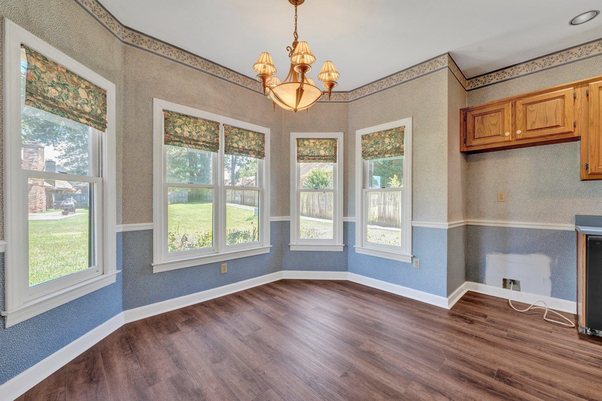 4149 Old Forest Road Memphis, TN 38125 - Photo 17 of 32 Unfurnished dining area featuring plenty of natural light, an inviting chandelier, and dark wood-type flooring