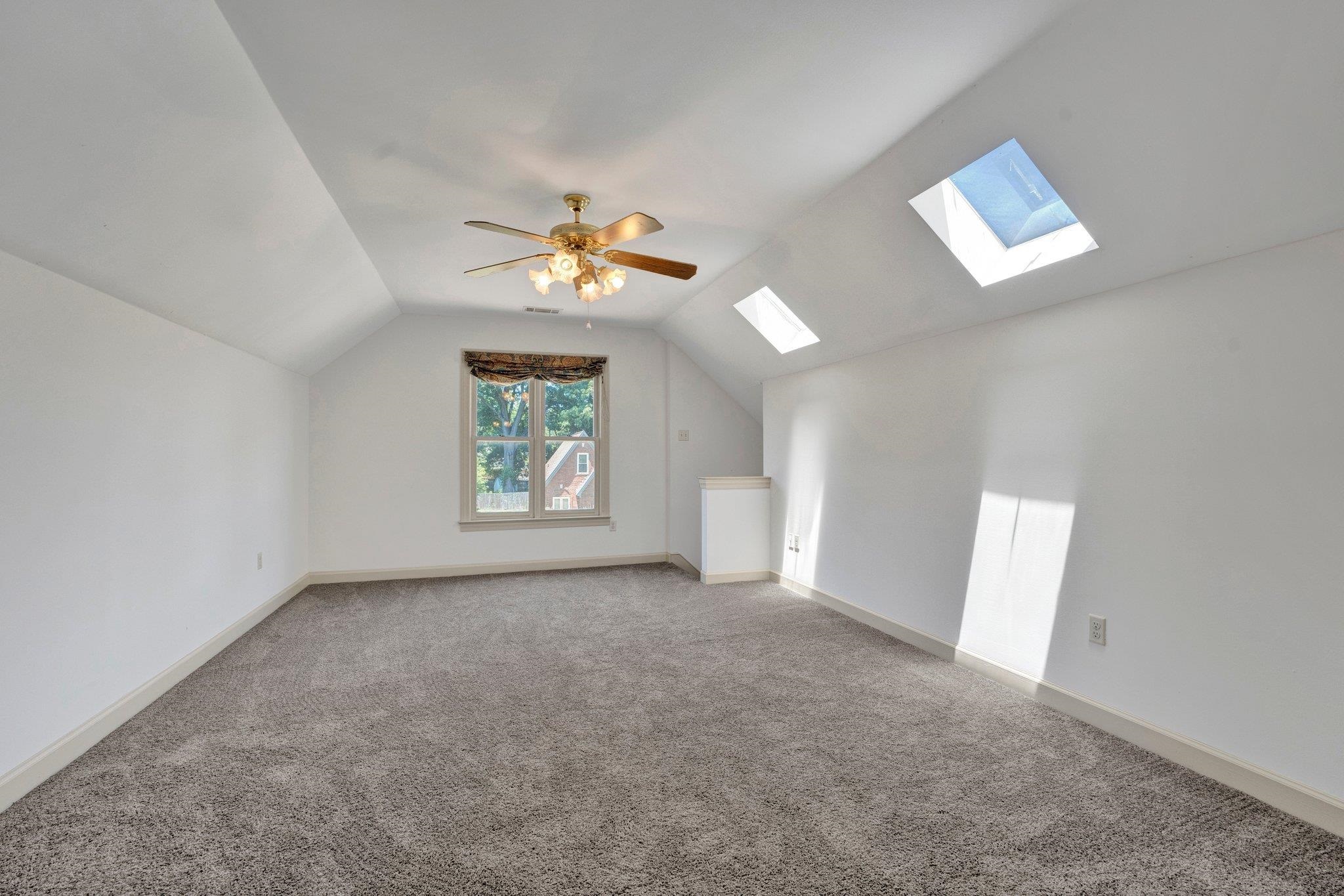 4149 Old Forest Road Memphis, TN 38125 - Photo 23 of 32 Additional living space with carpet flooring, lofted ceiling with skylight, and ceiling fan