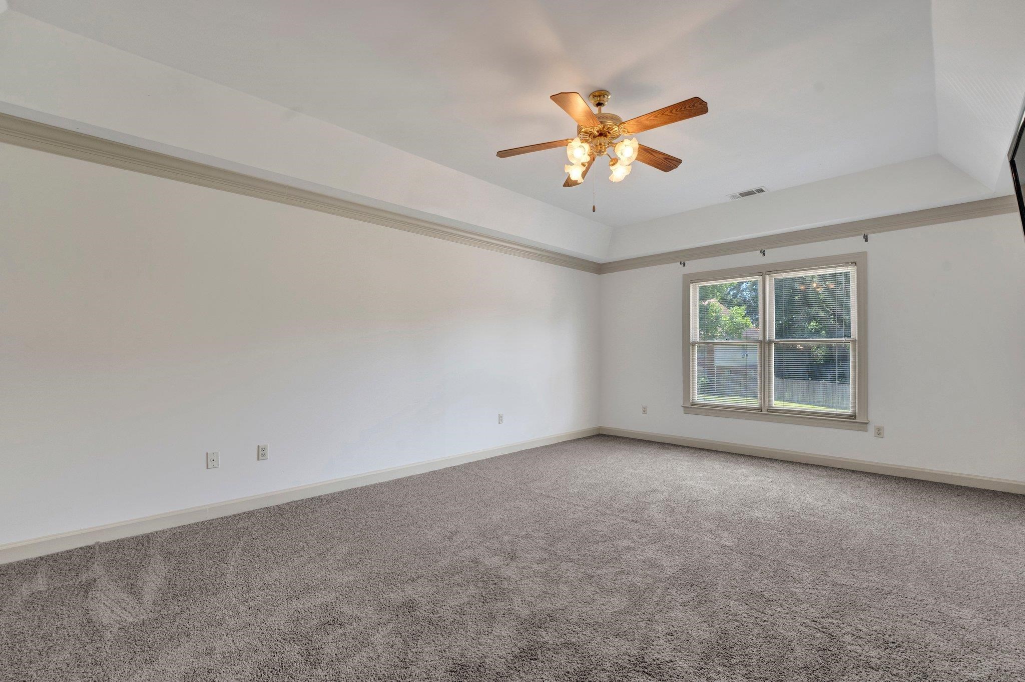 4149 Old Forest Road Memphis, TN 38125 - Photo 26 of 32 Carpeted empty room featuring ceiling fan and a tray ceiling