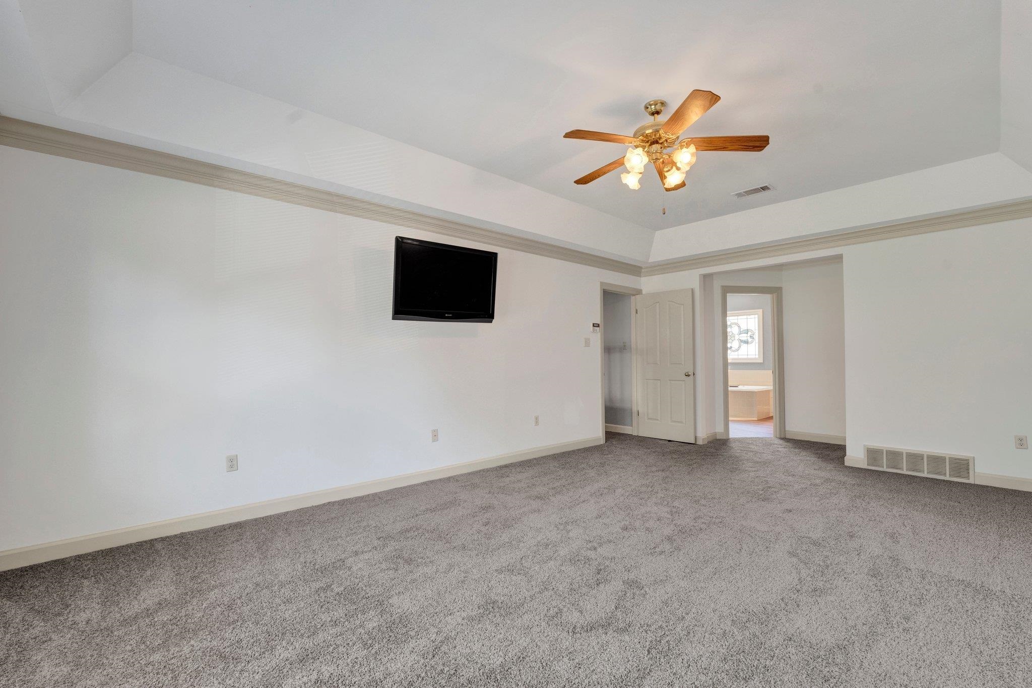 4149 Old Forest Road Memphis, TN 38125 - Photo 27 of 32 Carpeted spare room with ceiling fan and a raised ceiling