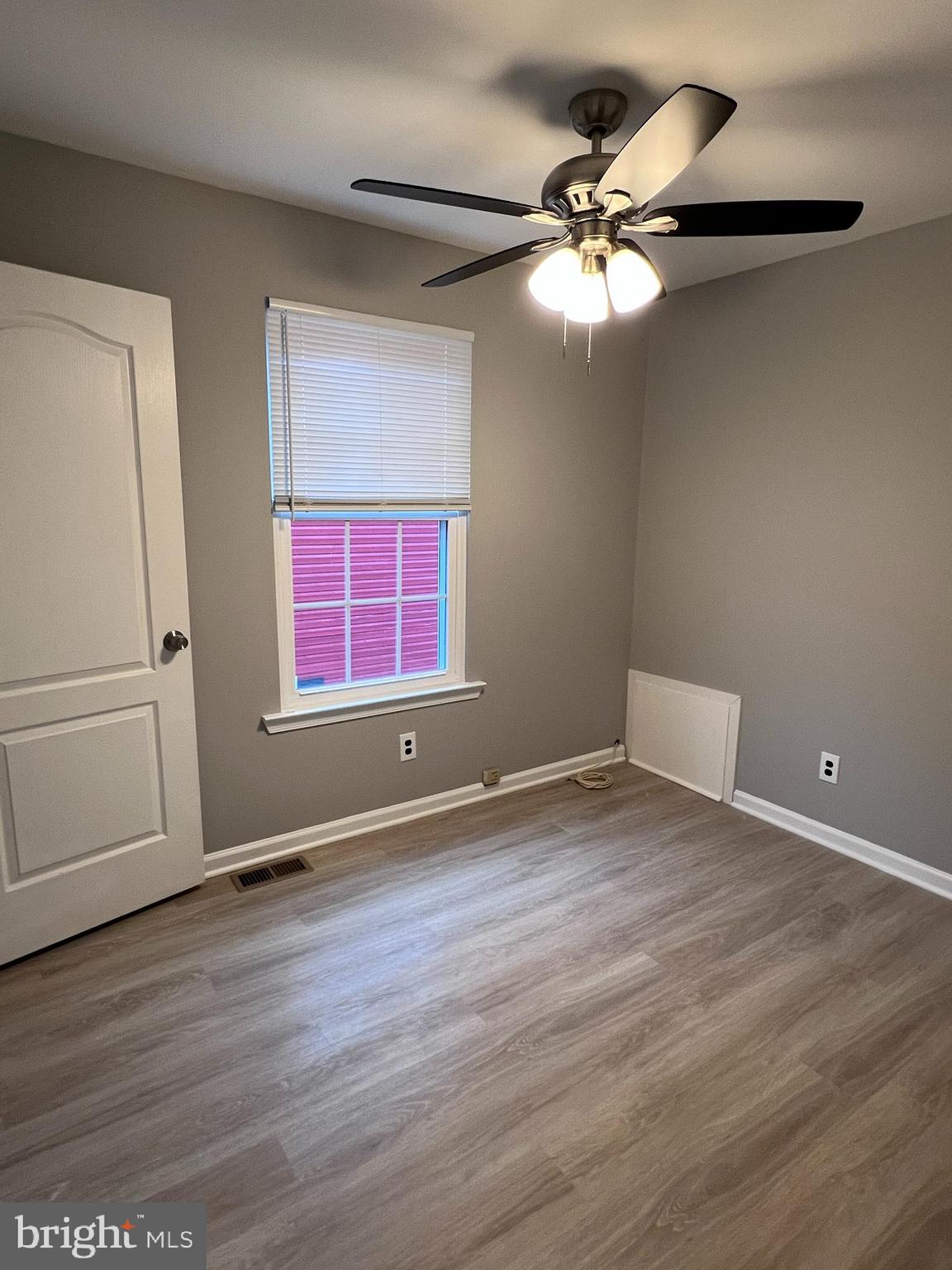 114 Gloucester Avenue Lawnside, NJ 08045 - Photo 14 of 22 an empty room with wooden floor fan and windows