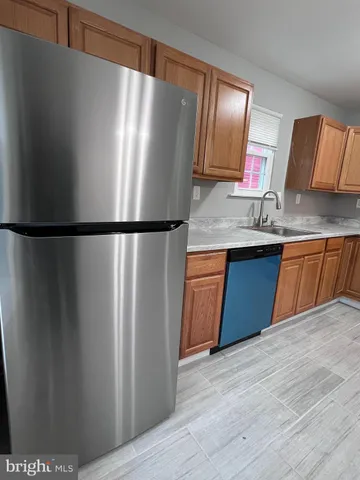 a kitchen with stainless steel appliances granite countertop a refrigerator a sink and dishwasher