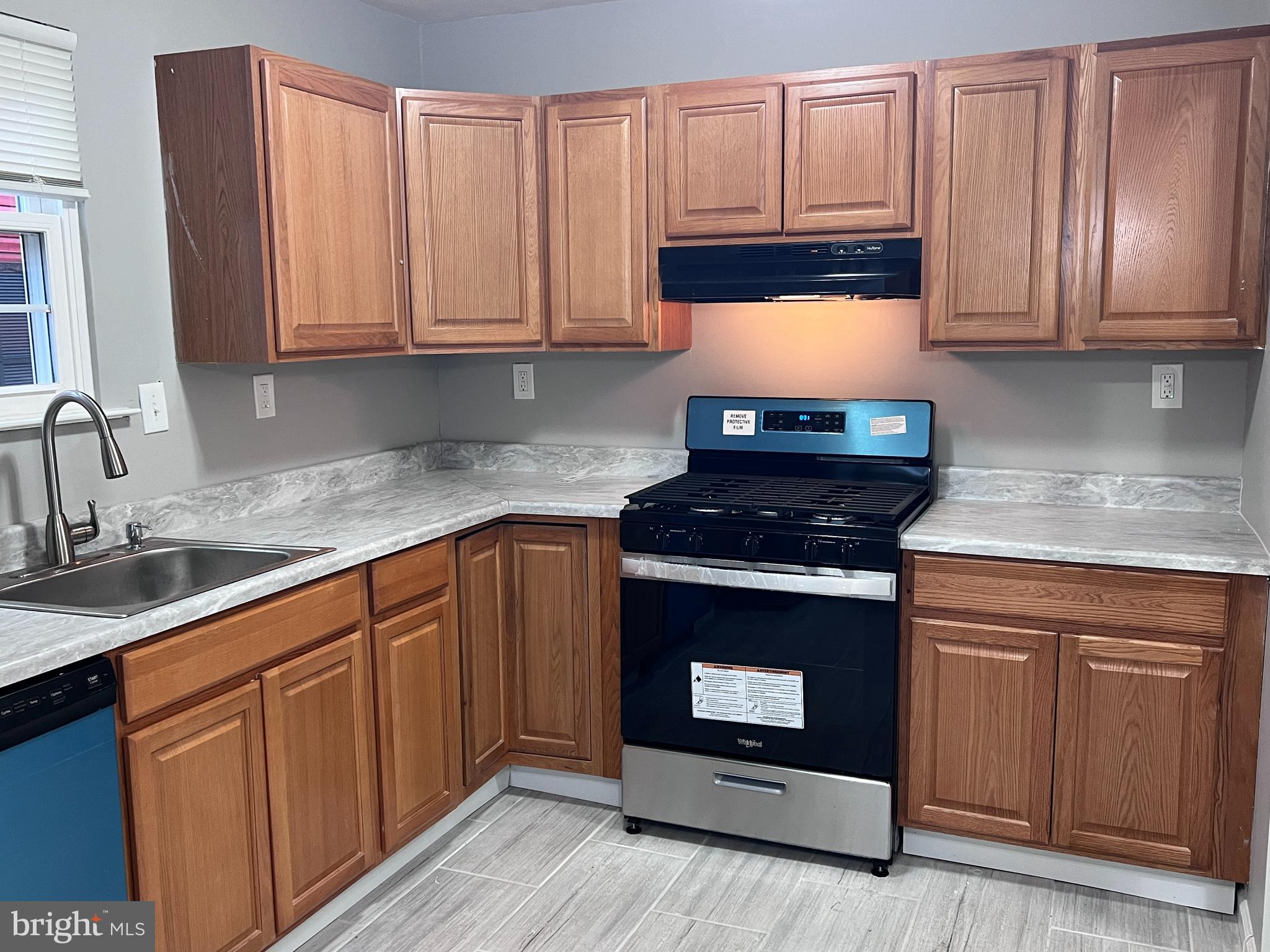 114 Gloucester Avenue Lawnside, NJ 08045 - Photo 3 of 22 a kitchen with granite countertop a stove top oven sink and cabinets