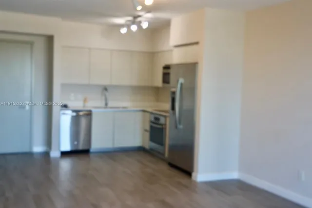 a kitchen with stainless steel appliances a refrigerator sink and cabinets