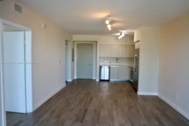 a view of a kitchen with wooden floor and a sink