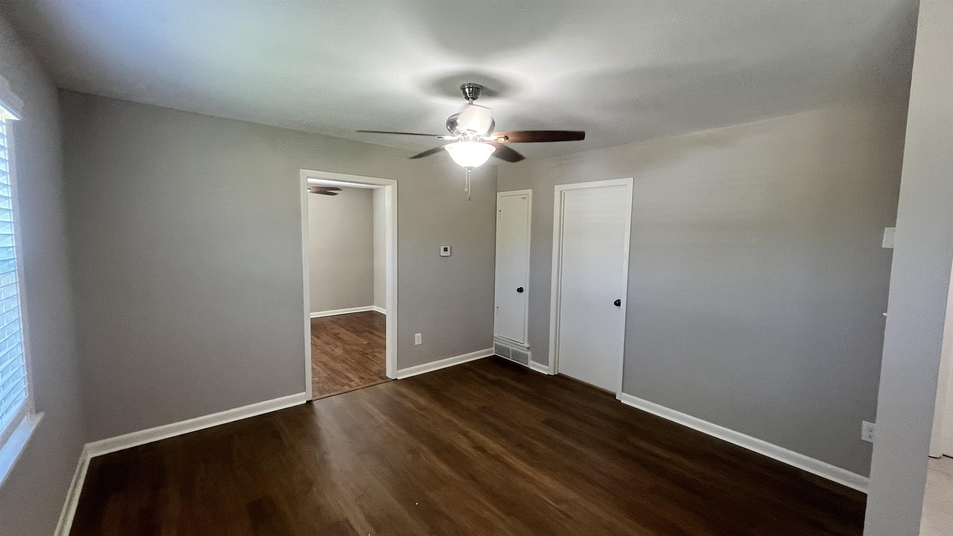 121 West Street Collierville, TN 38017 - Photo 15 of 16 a view of an empty room with window wooden floor and a chandelier fan
