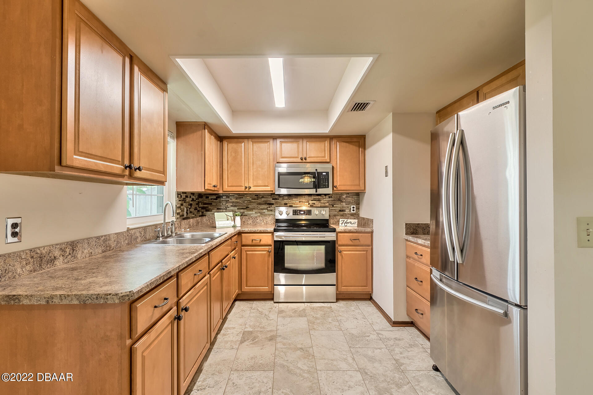 8 Greenfern Circle Ormond Beach, FL 32174 - Photo 10 of 25 a kitchen with stainless steel appliances granite countertop a refrigerator stove and sink