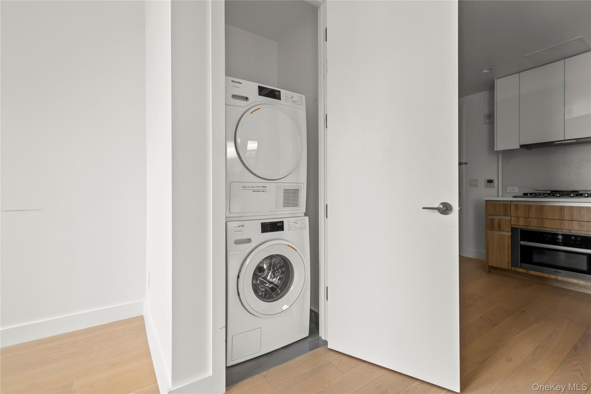 13618 Maple Avenue, Unit 5F Queens, NY 11355 - Photo 11 of 41 Laundry area with light wood-style floors and stacked washer / dryer