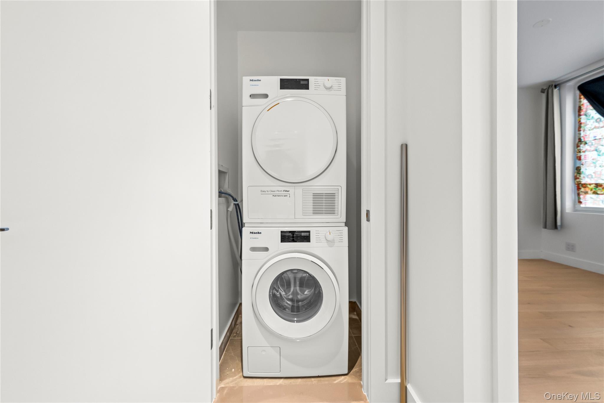 13618 Maple Avenue, Unit 5F Queens, NY 11355 - Photo 31 of 41 Laundry room with stacked washing machine and dryer and light wood-style floors