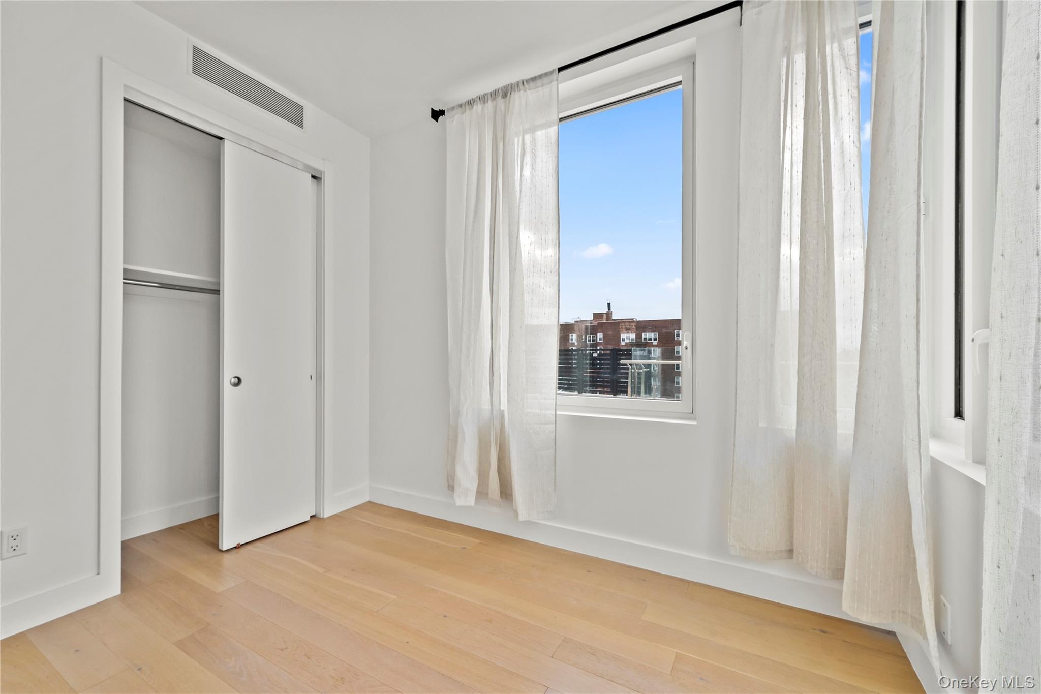 13618 Maple Avenue, Unit 5F Queens, NY 11355 - Photo 5 of 41 Unfurnished bedroom featuring hardwood / wood-style flooring and a closet