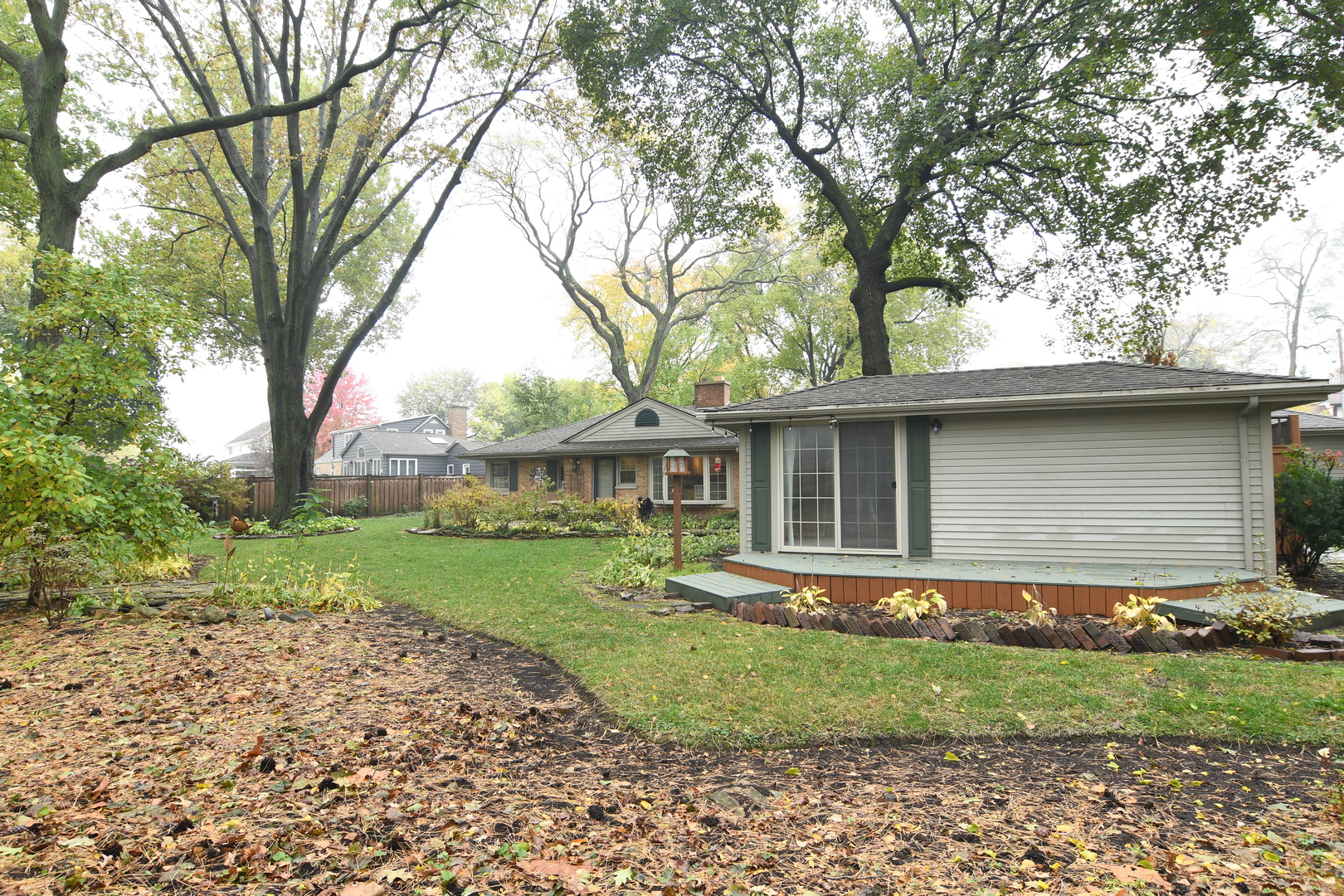 909 Warrenville Road Wheaton, IL 60189 - Photo 19 of 22 a front view of a house with a garden and trees