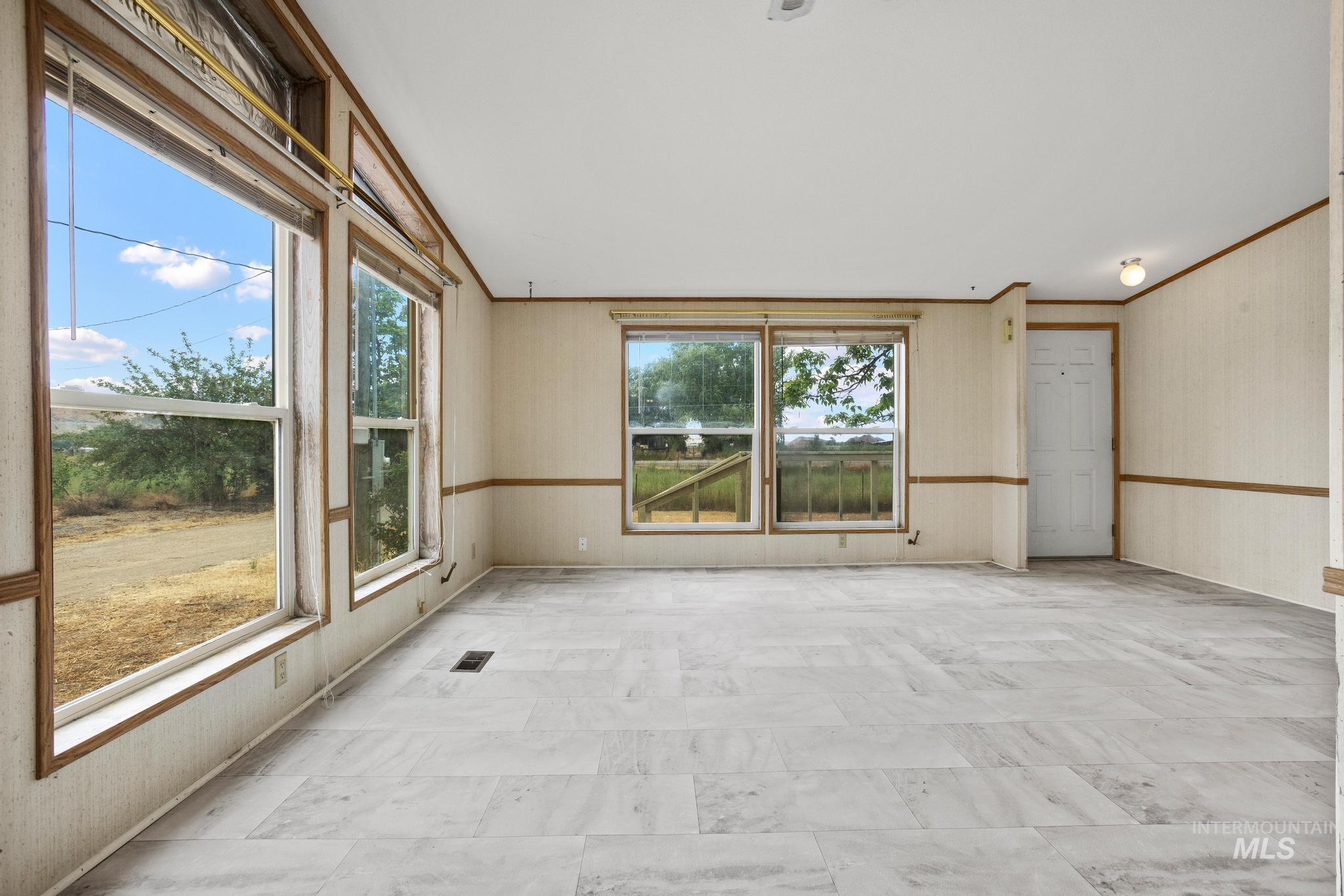 3680 South Mill Road Emmett, ID 83617 - Photo 11 of 38 Spacious interior featuring light-toned plank flooring, multiple large windows, and a neutral wall finish
