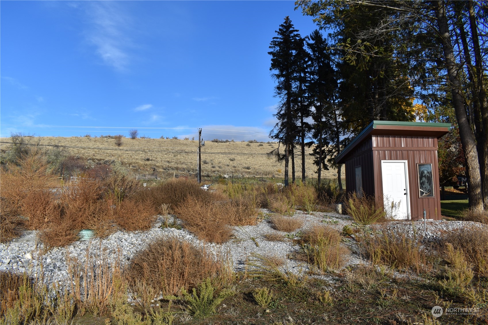 685 Loomis-Oroville Road Tonasket, WA 98855 - Photo 31 of 36 a view of a yard with a house in the background