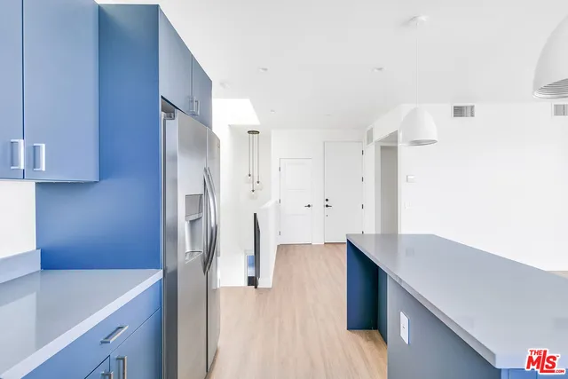 a kitchen with cabinets and a refrigerator