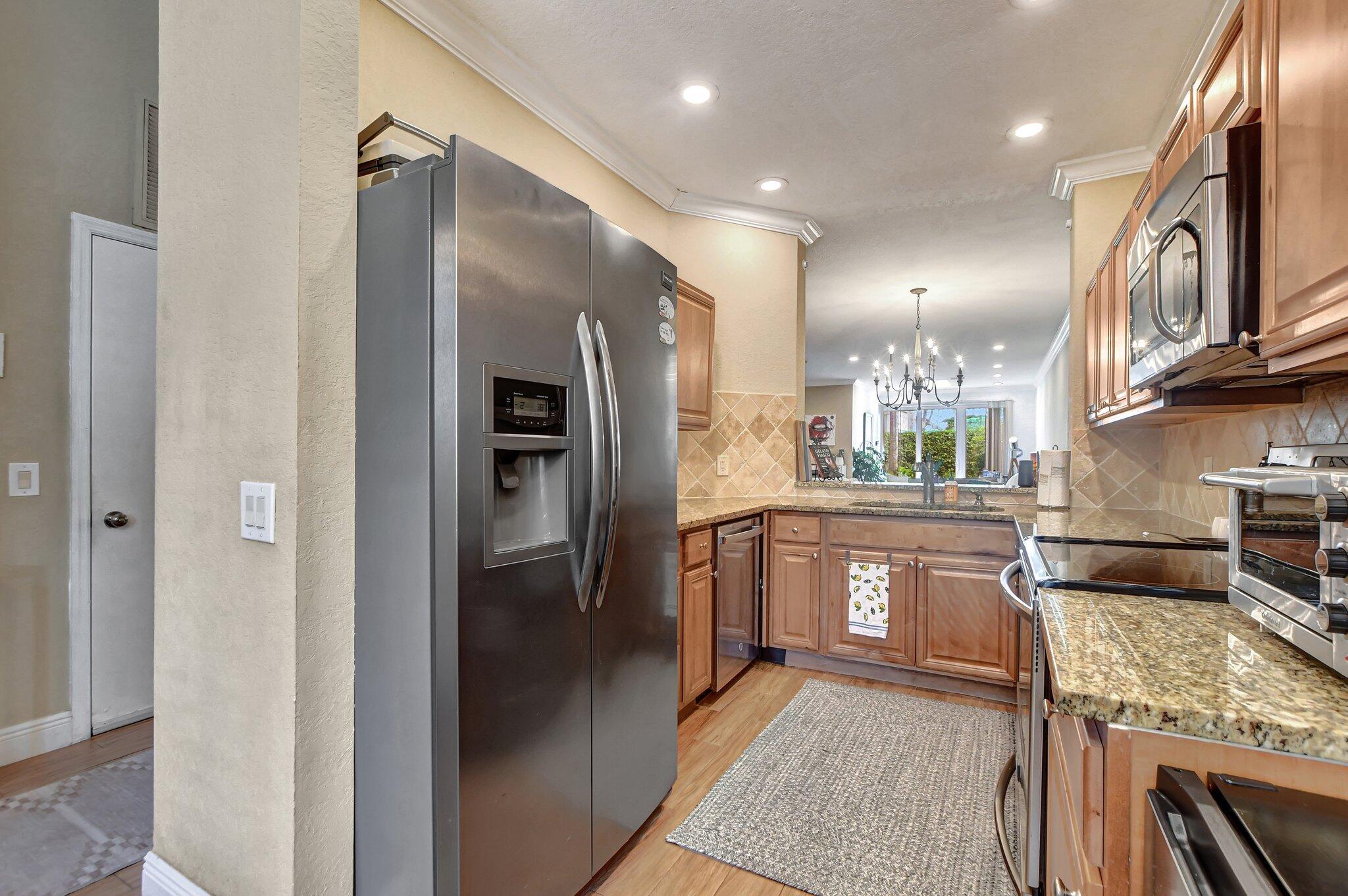 6682 Via Regina Boca Raton, FL 33433 - Photo 23 of 46 a kitchen with stainless steel appliances granite countertop a refrigerator a oven a sink and dishwasher