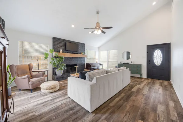 a living room with furniture a fireplace and a flat screen tv