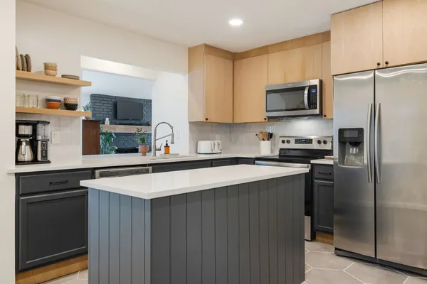 a kitchen with kitchen island a sink a stove and refrigerator