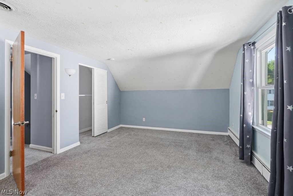 136 Pinehurst Road Munroe Falls, OH 44262 - Photo 26 of 48 Carpeted room featuring a window, built-in closet with bi-fold doors, and a wall-mounted light fixture