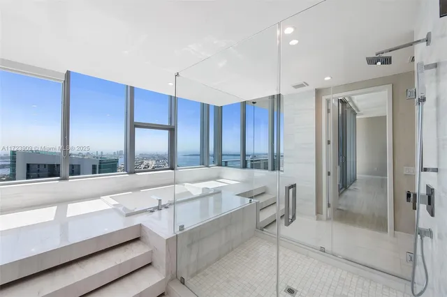 a large white kitchen with a large window and stainless steel appliances
