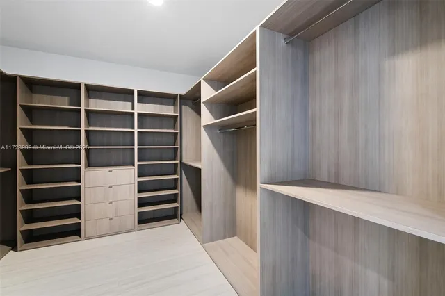 a view of walk in closet with empty racks