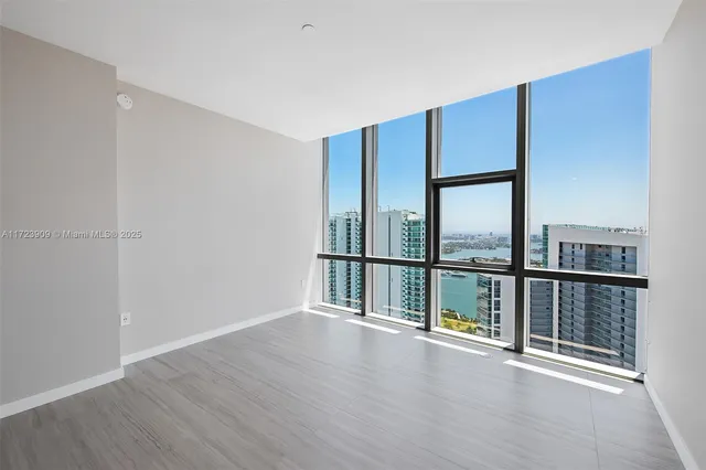a view of an empty room with wooden floor and closet