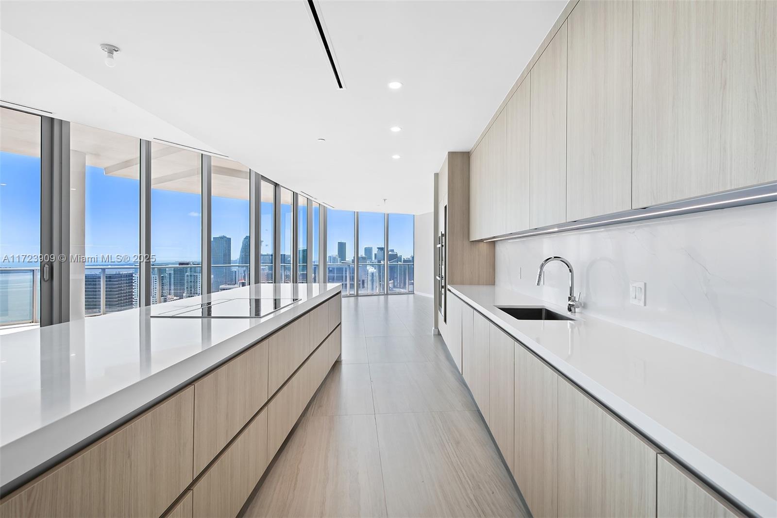 851 Northeast 1st Avenue, Unit PH5411 Miami, FL 33132 - Photo 6 of 40 a large kitchen with kitchen island a large window a sink and stainless steel appliances