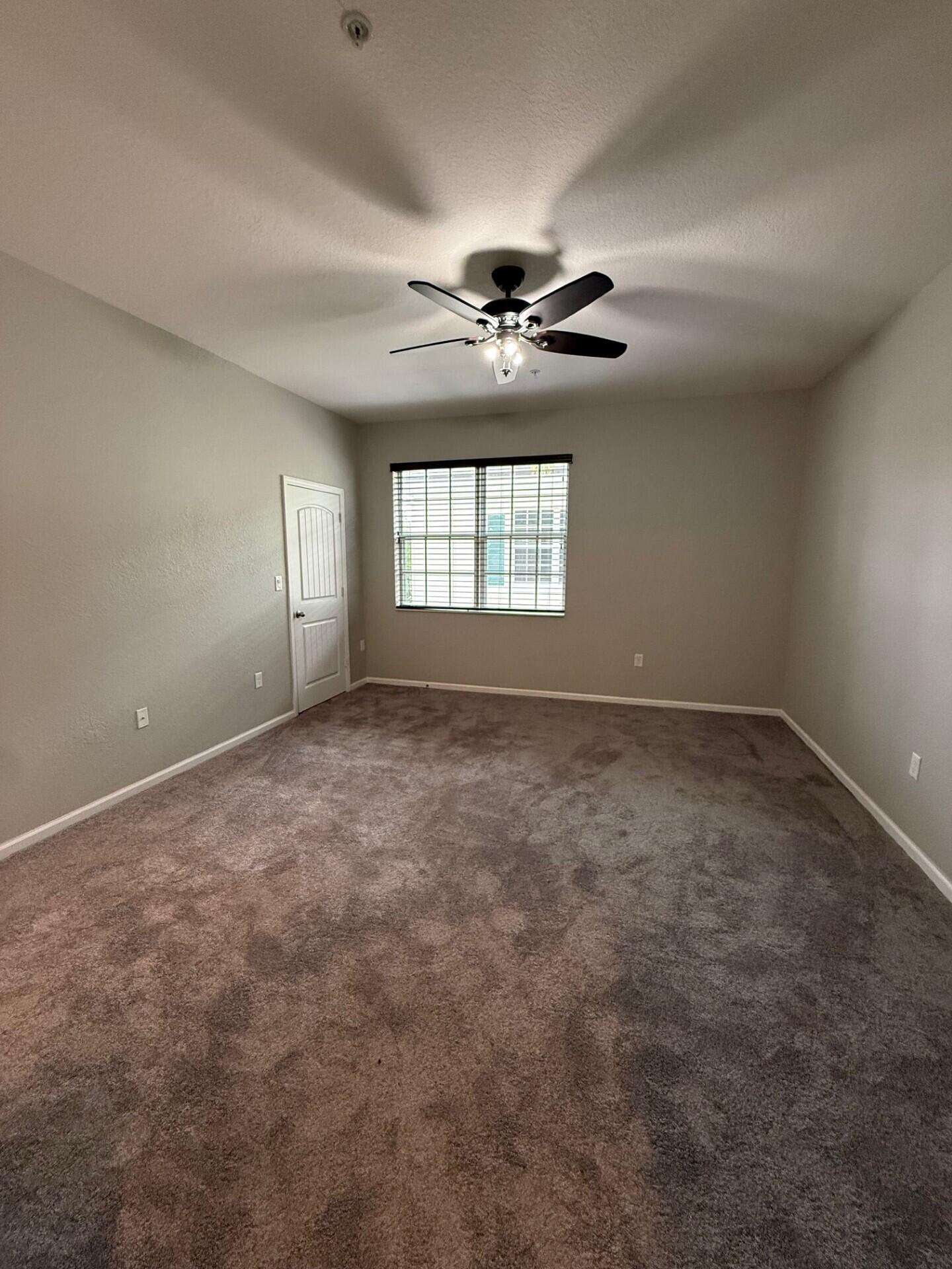 704 Southwest 2nd Way Pompano Beach, FL 33060 - Photo 12 of 22 an empty room with windows and ceiling fan