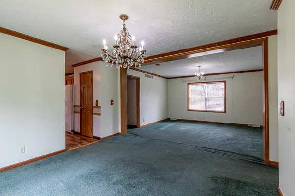 an empty room with windows and chandelier