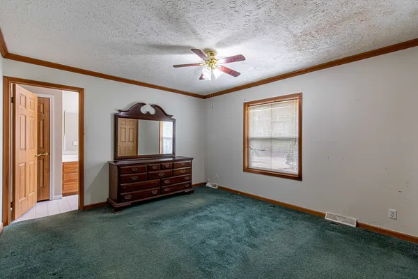 an empty room with windows and ceiling fan