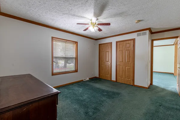 an empty room with windows and ceiling fan