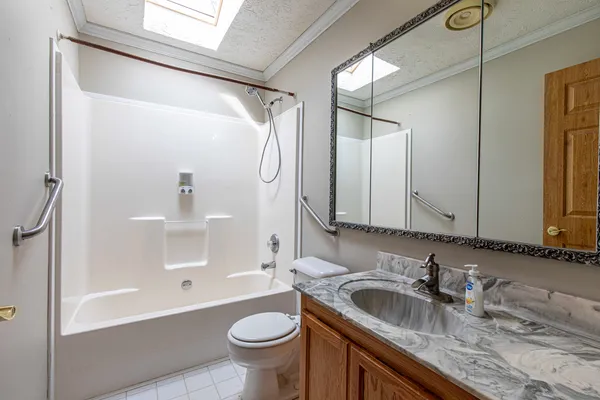 a bathroom with a granite countertop sink toilet and shower