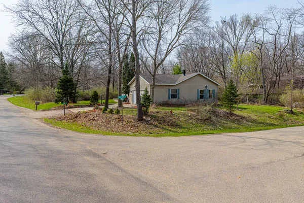 a view of a house with a big yard and large trees