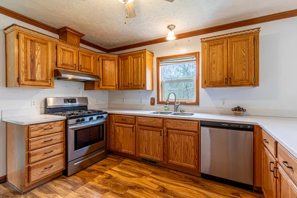 a kitchen with stainless steel appliances granite countertop a sink stove and cabinets