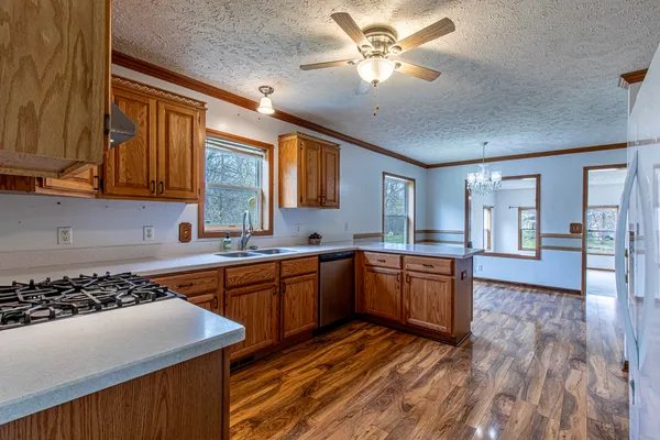 a kitchen with stainless steel appliances granite countertop a stove a sink dishwasher and a refrigerator