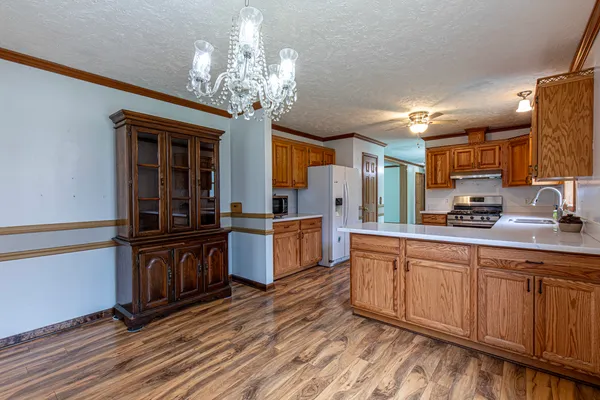 a large kitchen with stainless steel appliances wooden floors and a view of living room