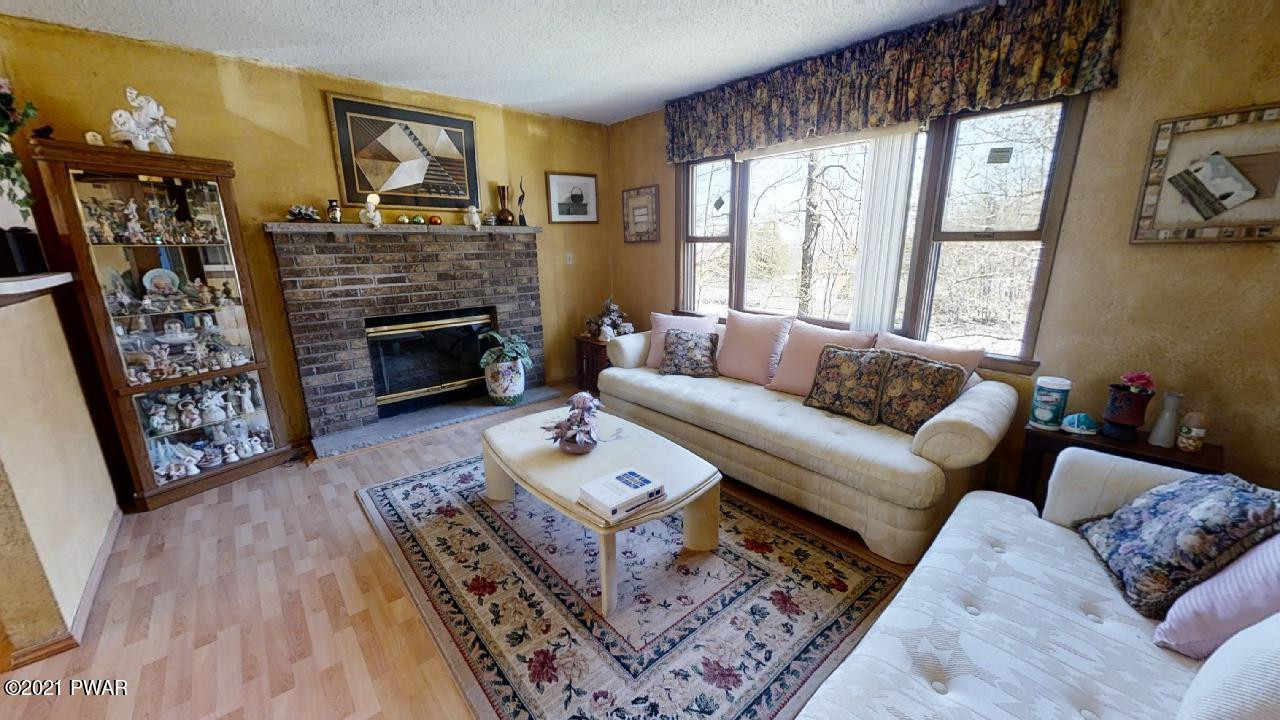 133 Skyview Road Dingmans Ferry, PA 18328 - Photo 2 of 15 a living room with furniture a flat screen tv and a fireplace