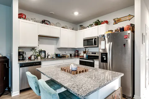 a kitchen with granite countertop a refrigerator stove and oven