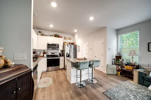 a kitchen with a sink cabinets stainless steel appliances and windows