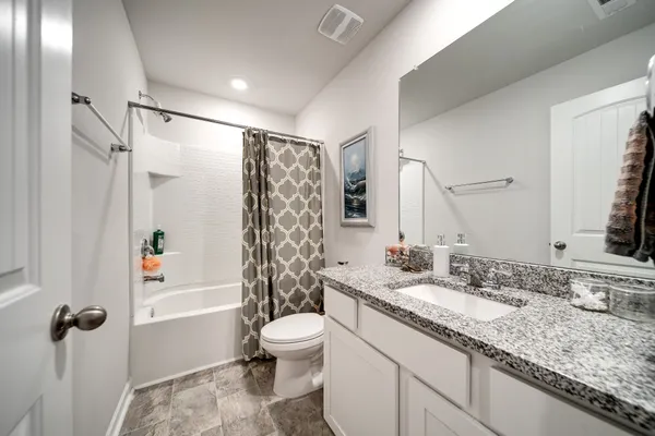 a bathroom with a granite countertop sink toilet and shower