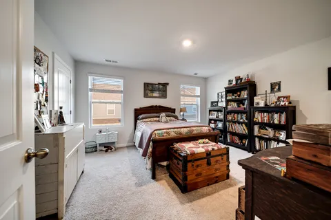 a bedroom with a bed furniture window and book shelf