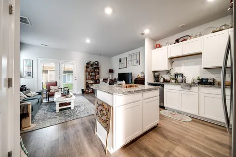 a kitchen with stove and wooden floor