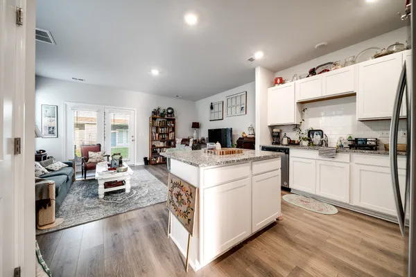 a kitchen with stove and wooden floor