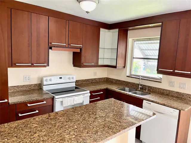 a kitchen with stainless steel appliances granite countertop a stove a sink and a microwave