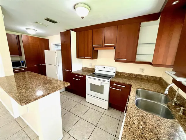 a kitchen with stainless steel appliances granite countertop a refrigerator and a sink