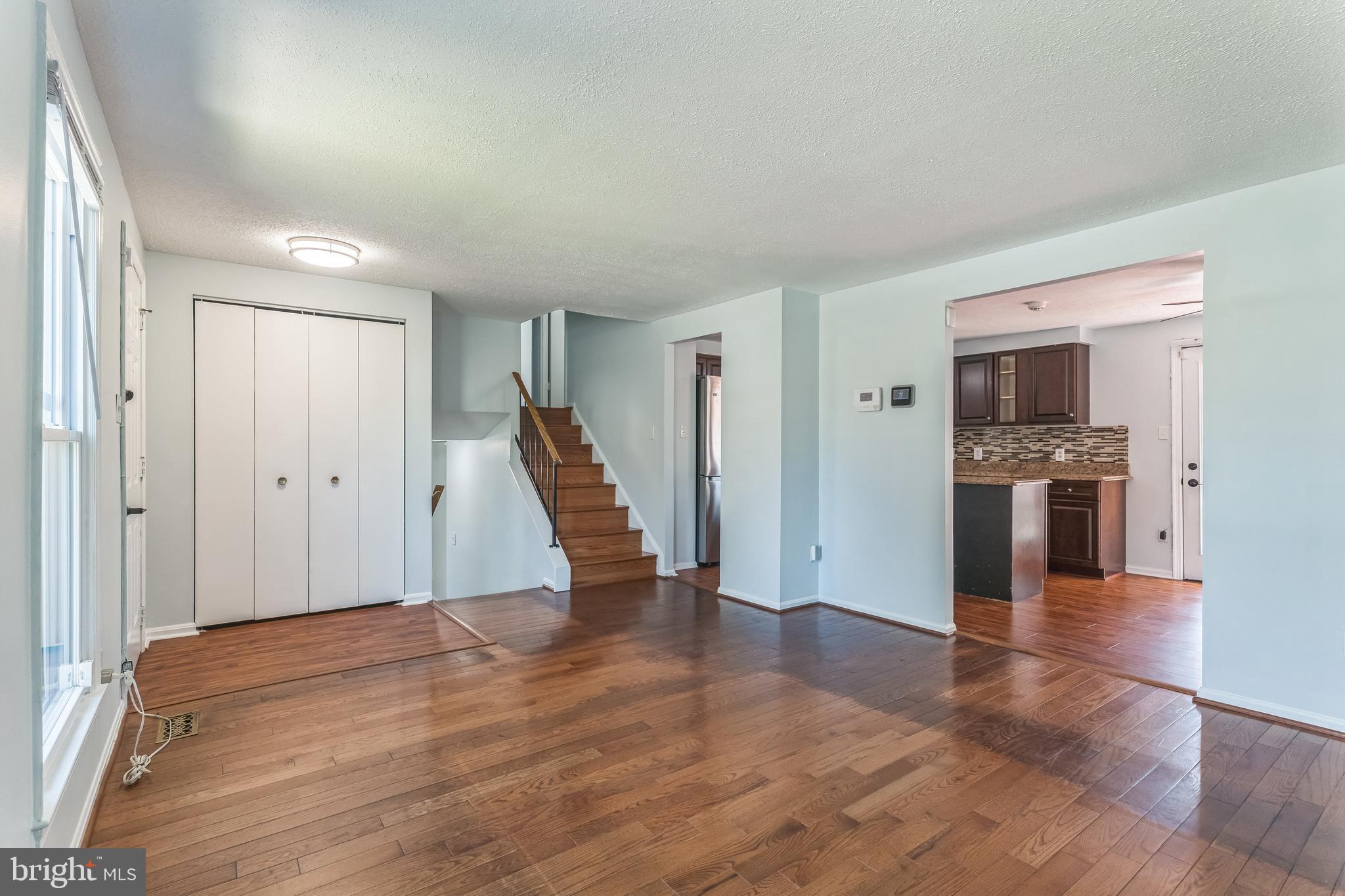 13106 North Point Lane Laurel, MD 20708 - Photo 2 of 30 a view of an empty room with wooden floor and a kitchen