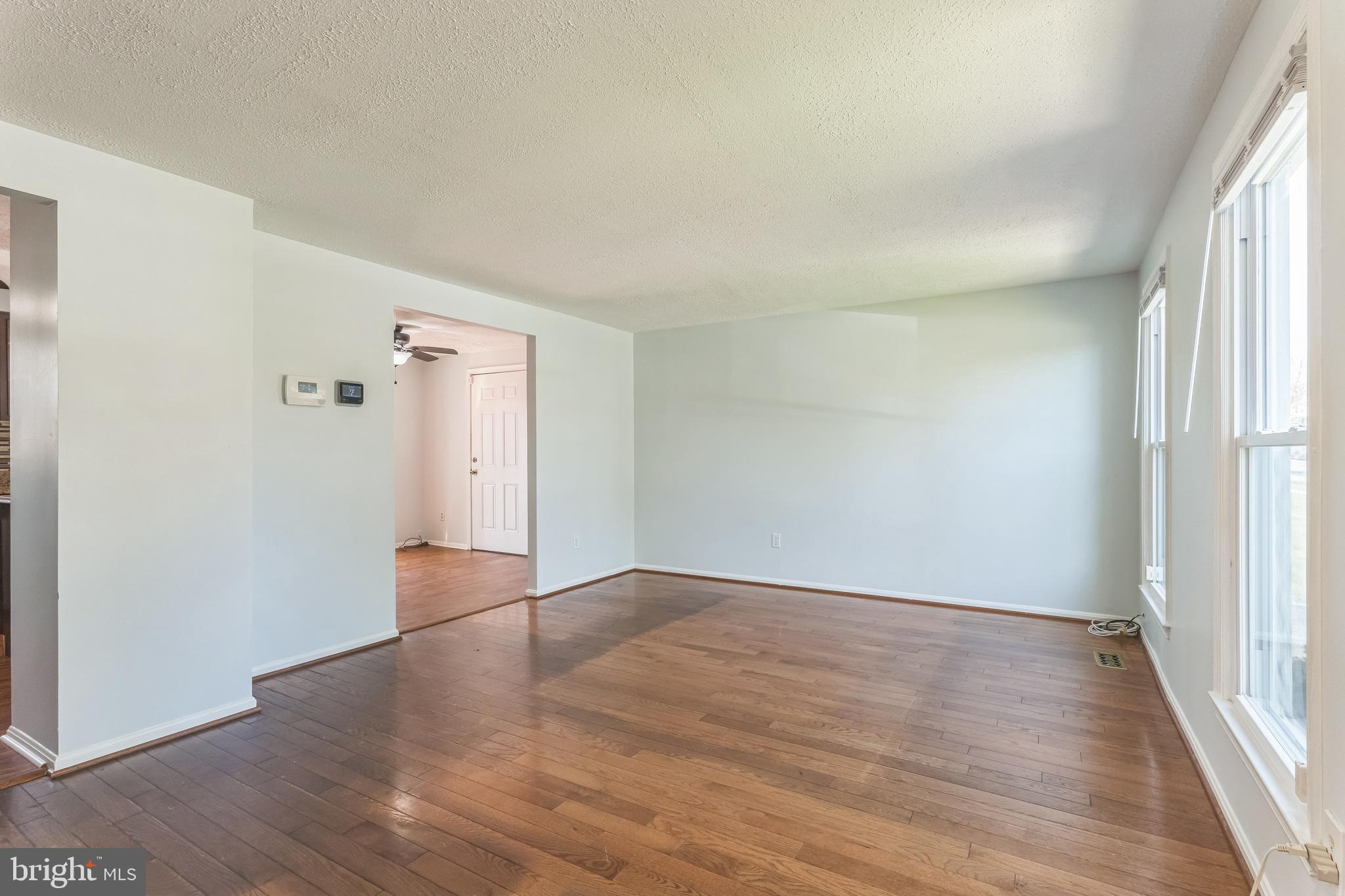 13106 North Point Lane Laurel, MD 20708 - Photo 3 of 30 an empty room with wooden floor and windows
