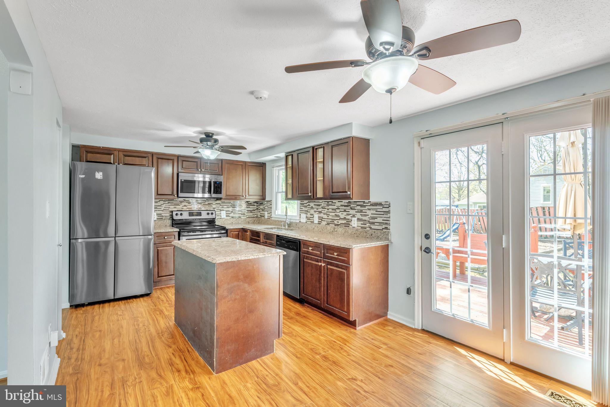 13106 North Point Lane Laurel, MD 20708 - Photo 6 of 30 a kitchen with stainless steel appliances granite countertop a refrigerator a stove a sink dishwasher a oven with a dining table and chairs