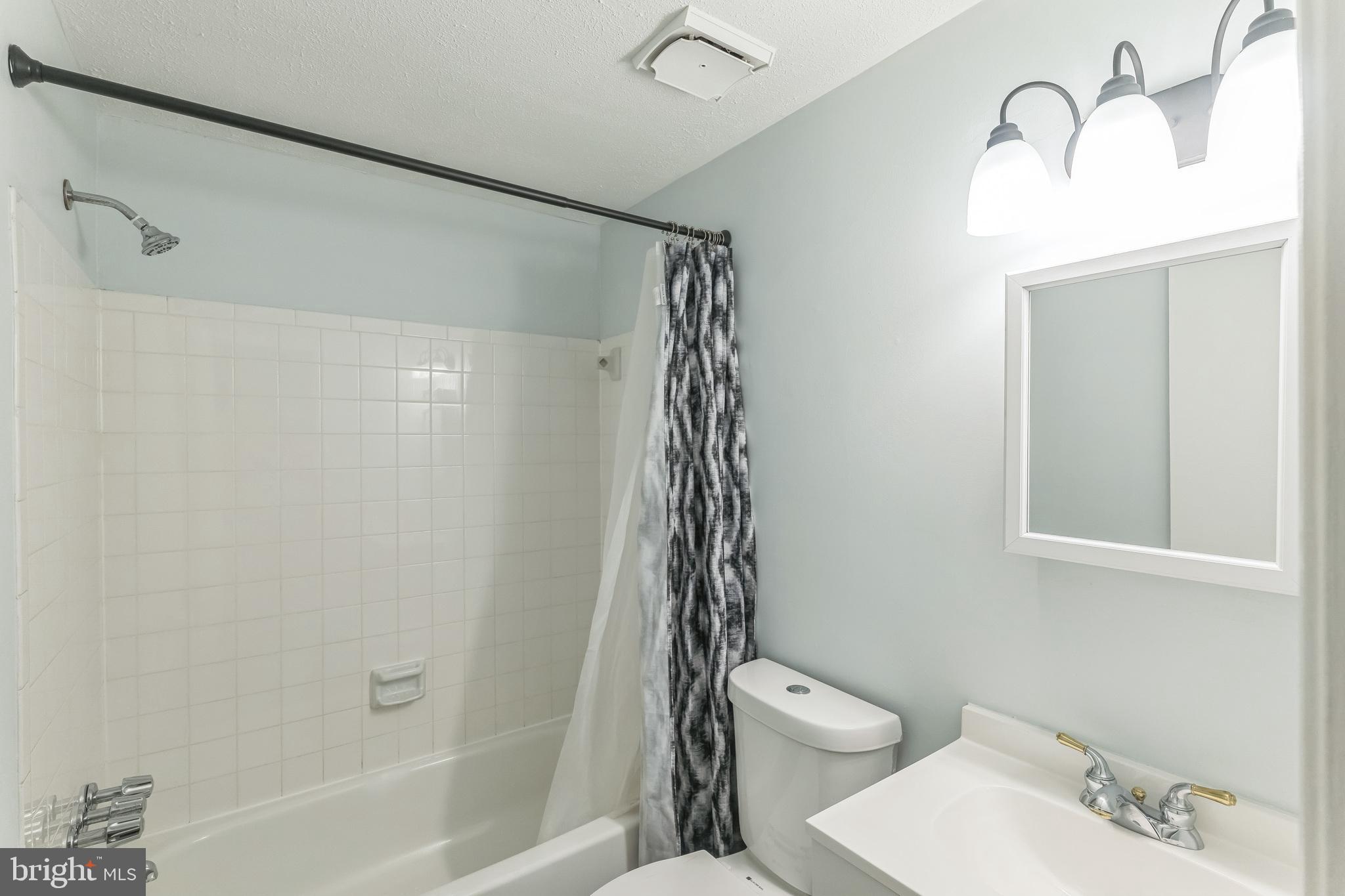 13106 North Point Lane Laurel, MD 20708 - Photo 9 of 30 a bathroom with a shower curtain and a sink