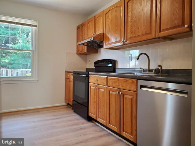 a kitchen with stainless steel appliances granite countertop a sink stove and cabinets
