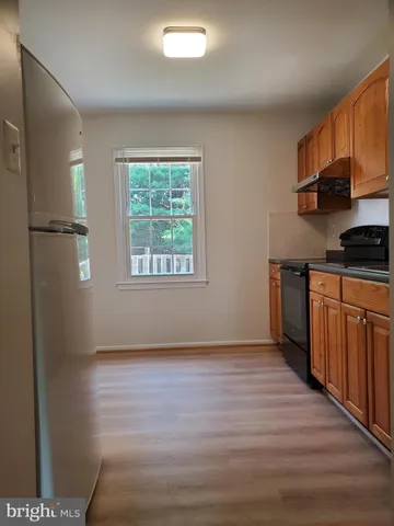 a kitchen with wooden floors and white cabinets